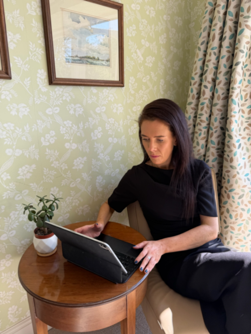 Ella working, laptop and a plant